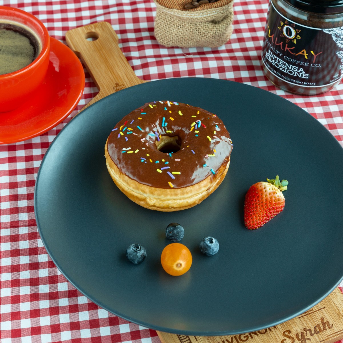 original image of a donut and some fruits on a plate next to a jar of jam on a red gingham tablecloth