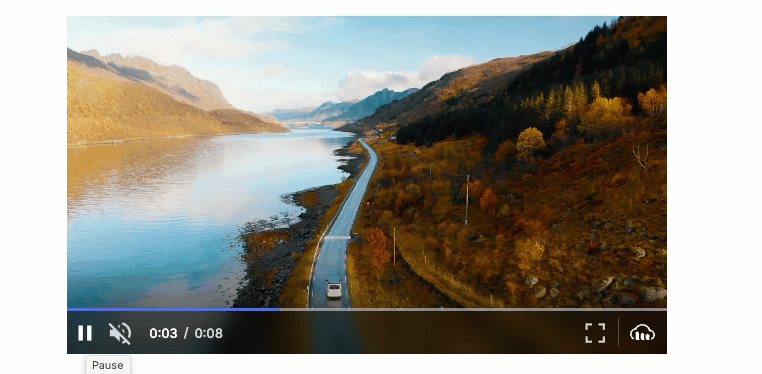 Cloudinary Video Player showing the volume slider. The video depicts a car driving down a road between a lake and mountain.